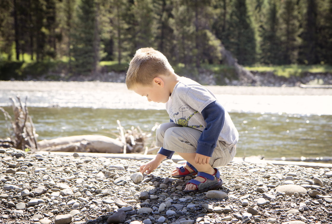 Boy squatting in a creek